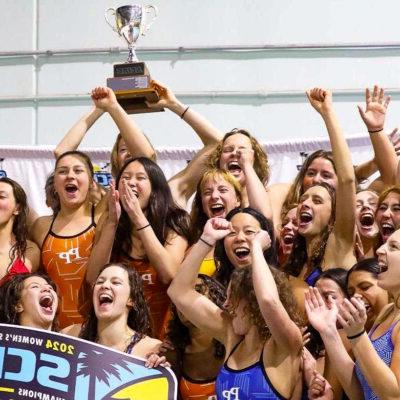 波莫纳-欧洲杯平台女子游泳队欢呼并举起SCIAC奖杯.
